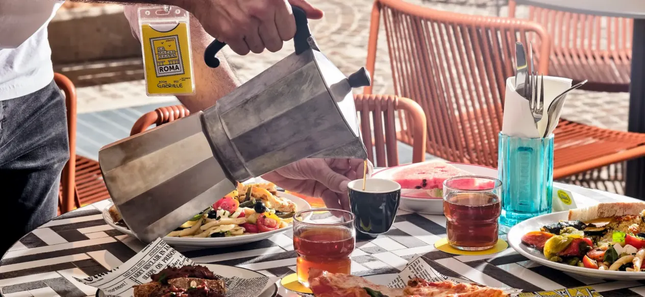 Table avec pizza, pâtes et boissons, café versé d'une cafetière moka au JO&JOE
