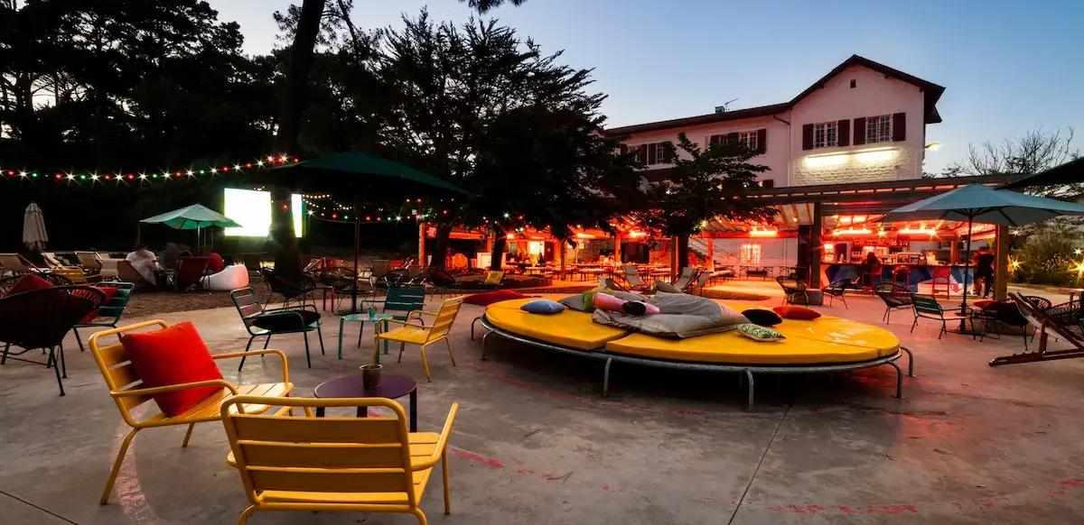 Terrasse extérieure avec chaises et guirlandes lumineuses au crépuscule au JO&JOE