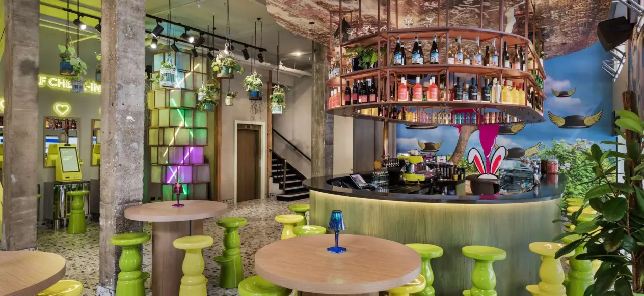 Bar rond avec tabourets verts et tables au JO&JOE Auckland