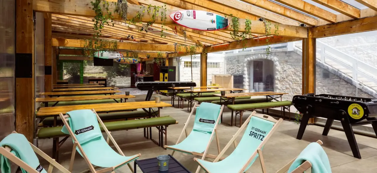 Terrasse couverte avec transats, tables de pique-nique et baby-foot au JO&JOE Hossegor
