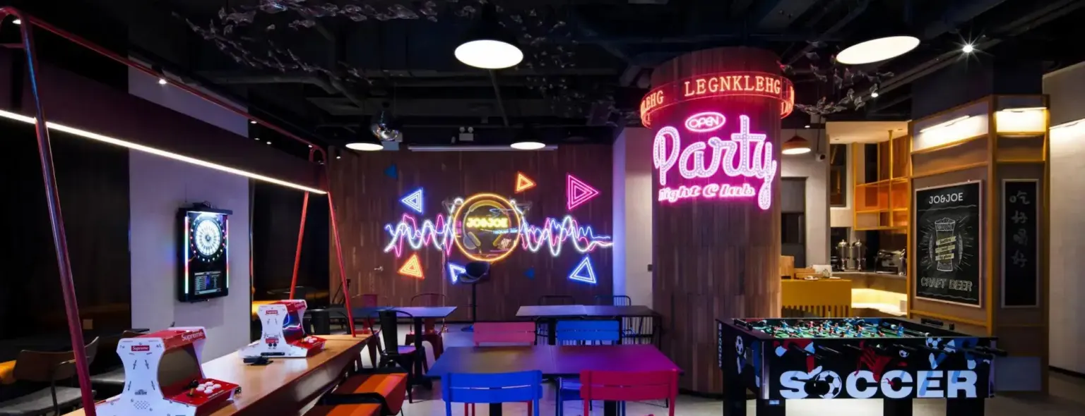 Bar lounge with neon signs and a foosball table at JO&JOE China
