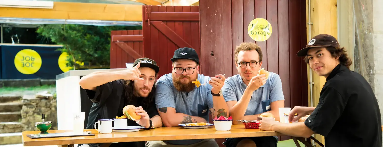 Clients prenant un repas autour d'une table en bois