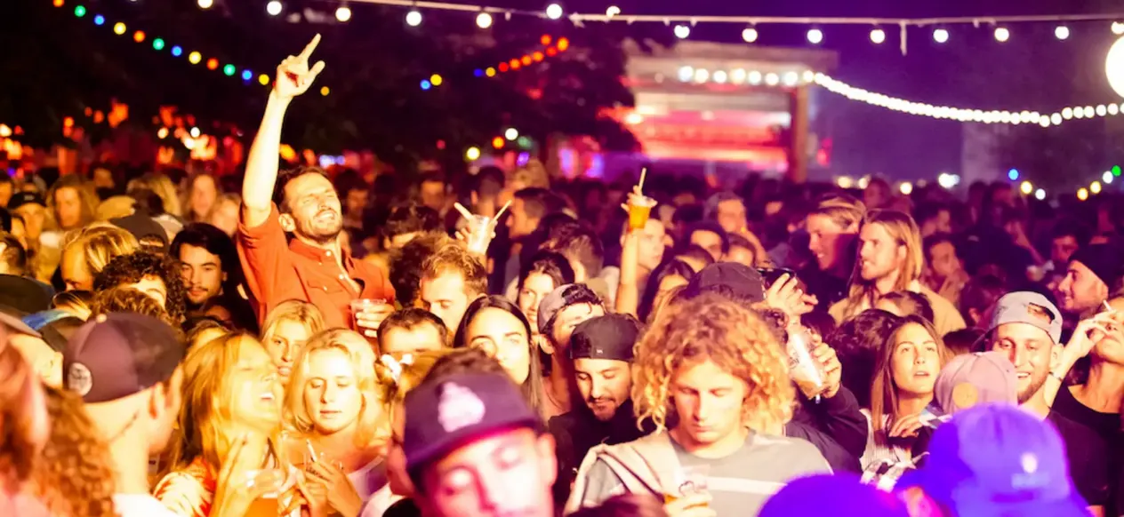 Foule lors d'un événement en plein air en soirée avec guirlandes lumineuses au JO&JOE