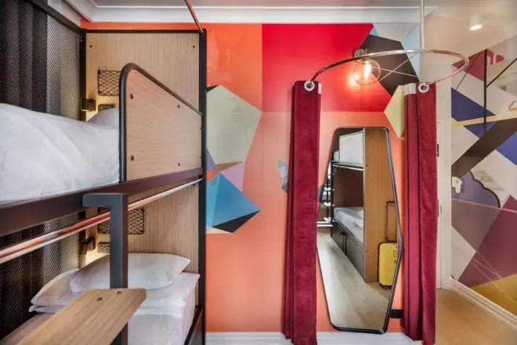 Chambre avec lit superposé, miroir et mur coloré au JO&JOE Auckland