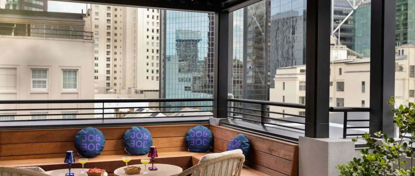 Terrasse sur le toit avec places assises et vue sur la ville au JO&JOE Auckland