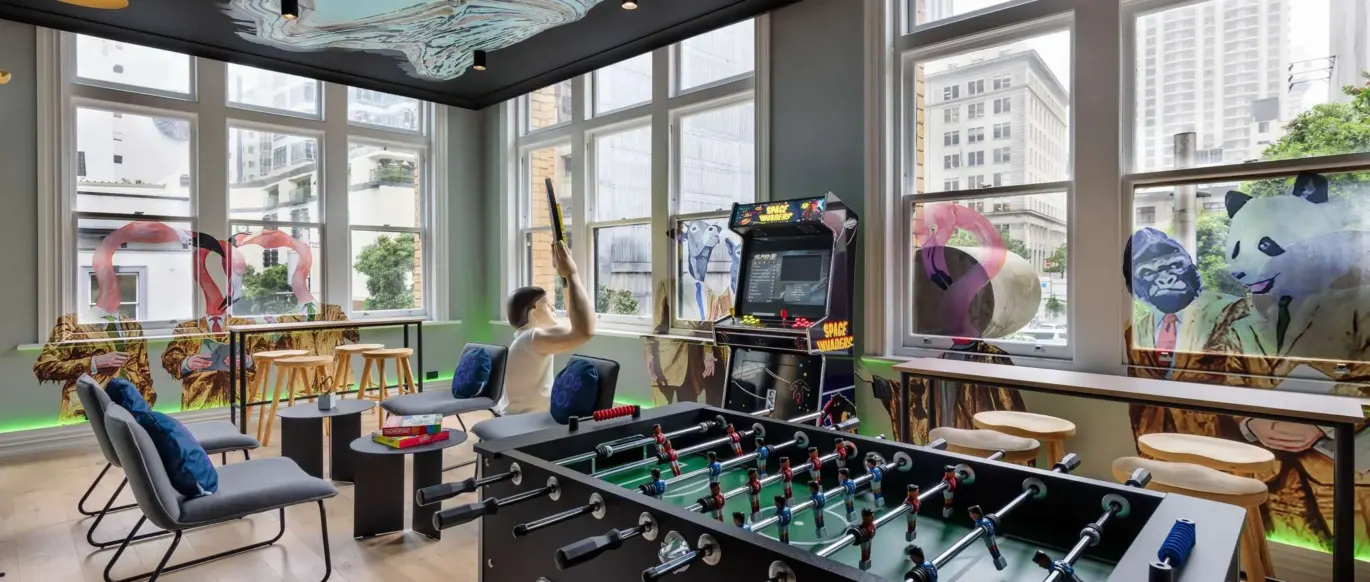 Salle de jeux avec baby-foot et borne d'arcade au JO&JOE Auckland