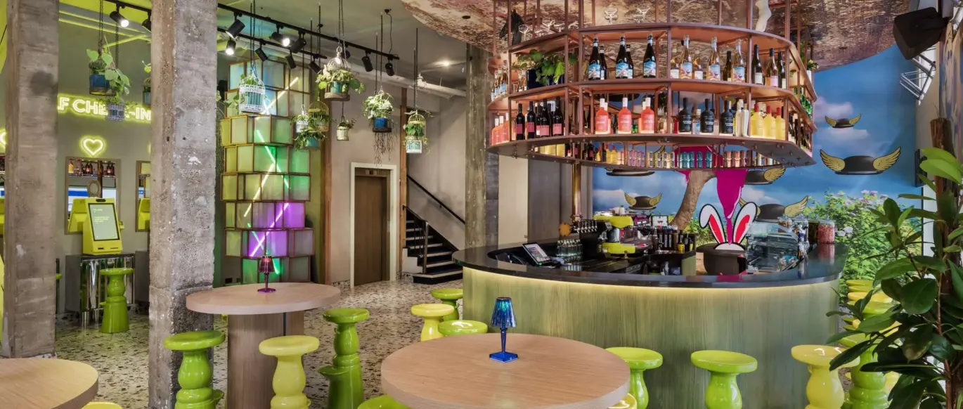 Bar avec tabourets verts et décor coloré au JO&JOE Auckland
