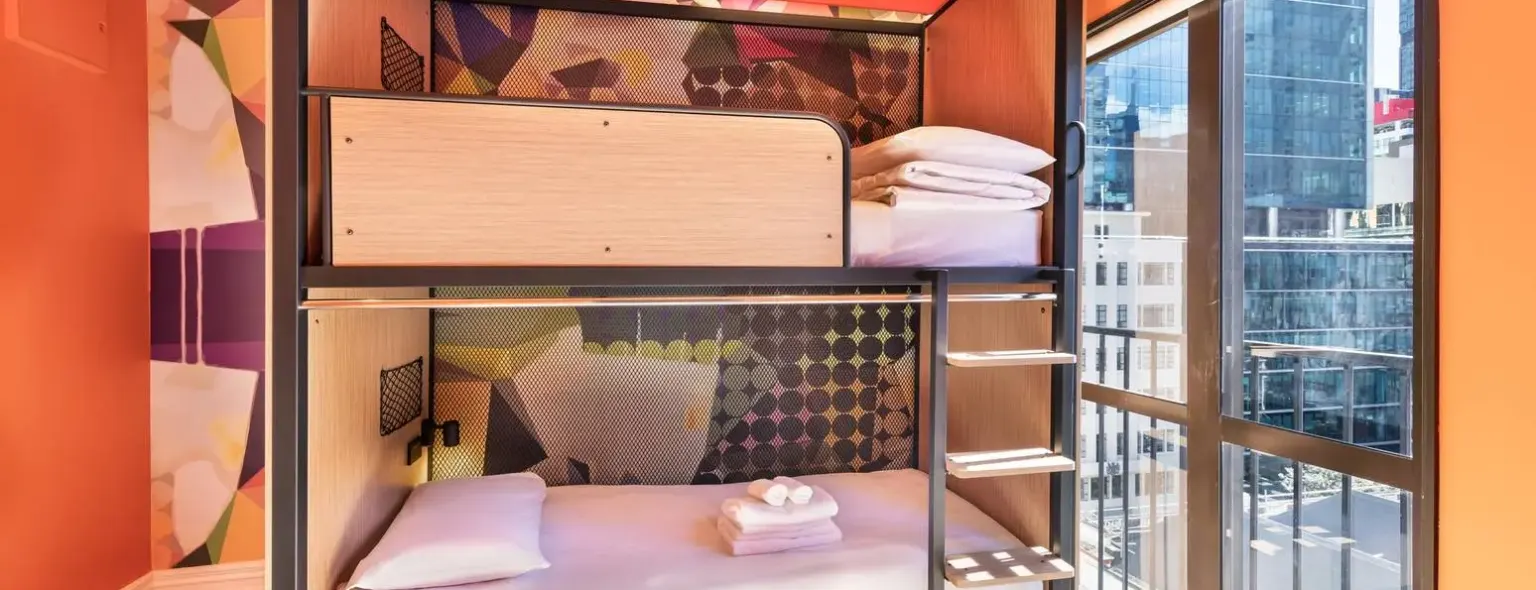 Chambre avec lit superposé et grande fenêtre au JO&JOE Auckland
