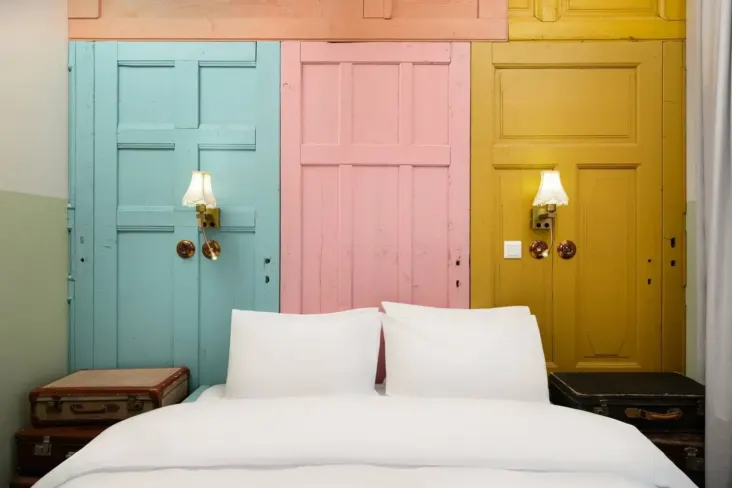Lit double avec tête de lit en portes de bois colorées au JO&JOE Budapest