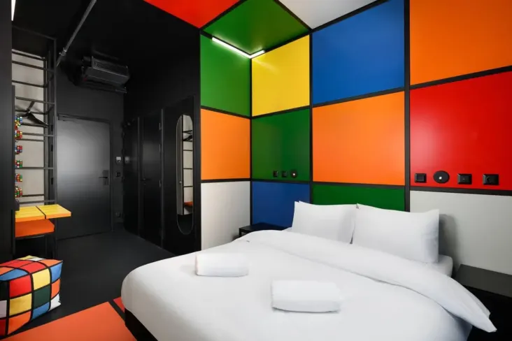 Chambre avec lit double et mur à motifs de blocs colorés au JO&JOE Budapest