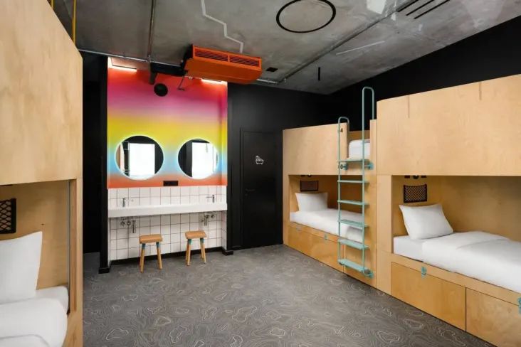 Dortoir avec lits superposés en bois et coin lavabos au JO&JOE Budapest