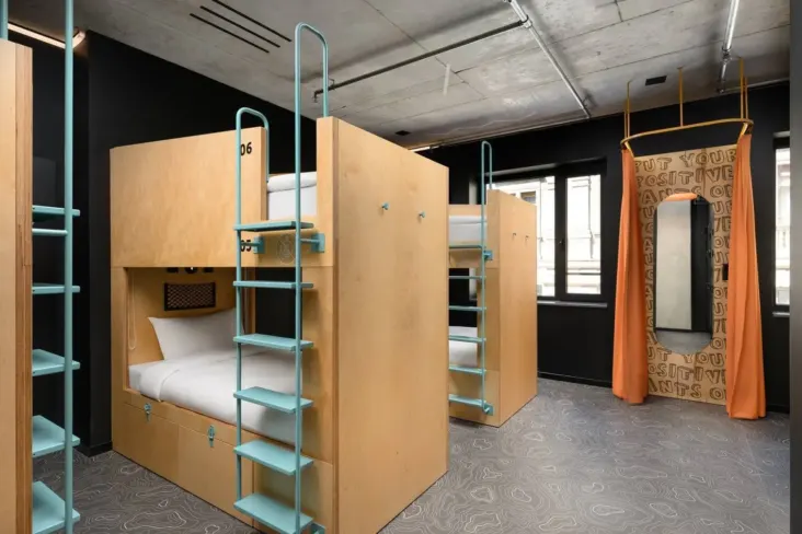 Dortoir avec lits superposés en bois et échelles au JO&JOE Budapest