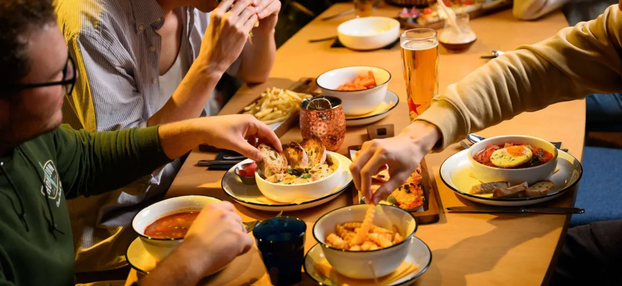 Pratos e bebidas em uma mesa compartilhada