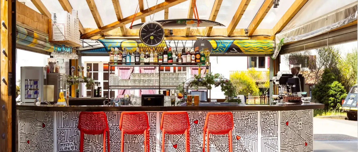 Bar extérieur avec tabourets rouges au JO&JOE Hossegor