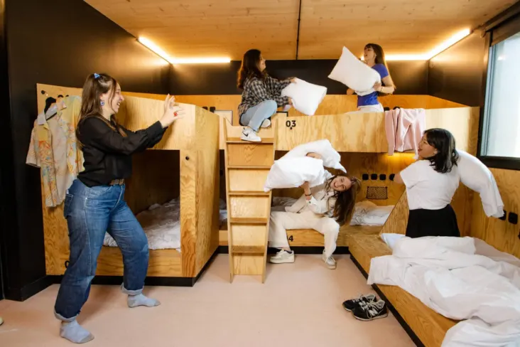 Clients dans un dortoir avec lits superposés en bois au JO&JOE Paris Gentilly