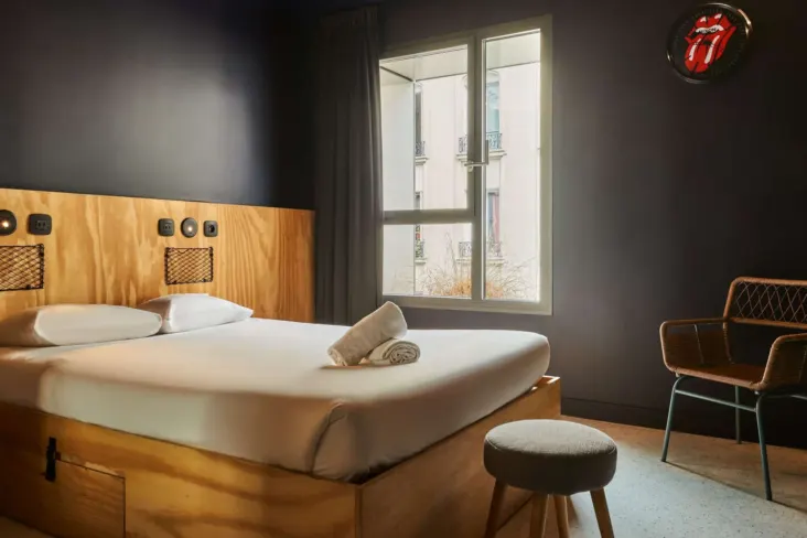 Chambre double avec lit en bois et fenêtre au JO&JOE Paris Nation