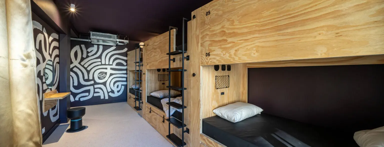 Dortoir avec lits superposés en bois et mur à motifs au JO&JOE Paris Nation