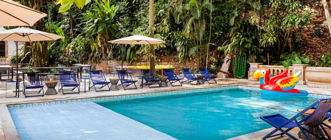 Piscine entourée d'arbres avec chaises longues au JO&JOE Rio de Janeiro