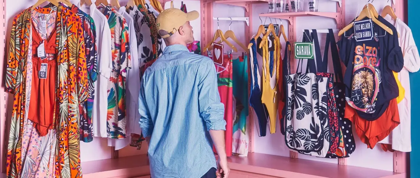 Vêtements et casquettes accrochés à des étagères roses au JO&JOE Rio de Janeiro