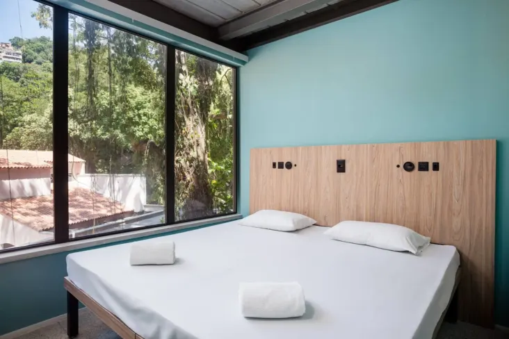 Chambre privée avec lit double et grande fenêtre au JO&JOE Rio de Janeiro