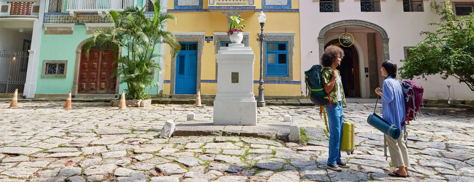 Voyageurs avec sacs à dos sur une place pavée à Rio de Janeiro