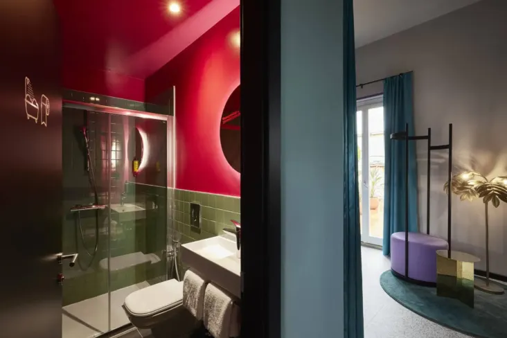 Chambre avec salle de douche et coin salon au JO&JOE Rome