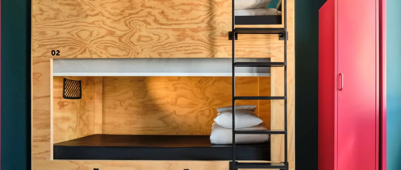 Lit superposé en bois et casier rouge dans une chambre au JO&JOE Rome