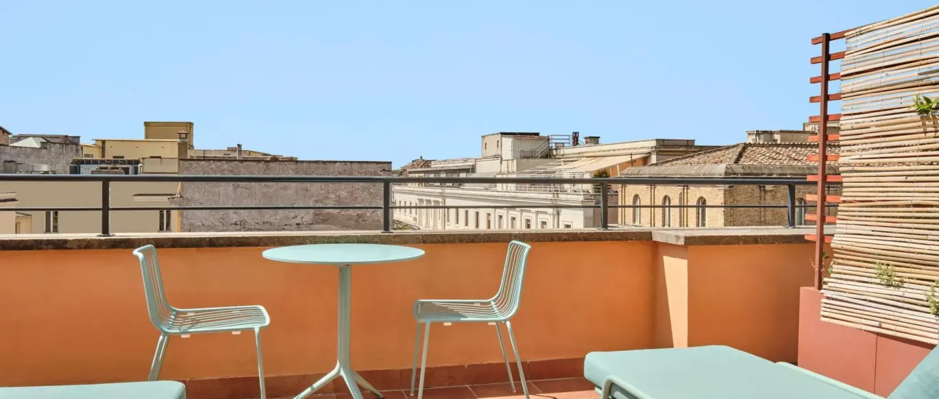 Terrasse avec table, chaises et bains de soleil au JO&JOE Rome