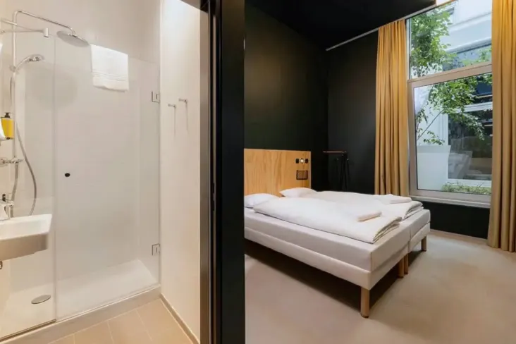 Chambre privée avec lit double et douche au JO&JOE Vienne