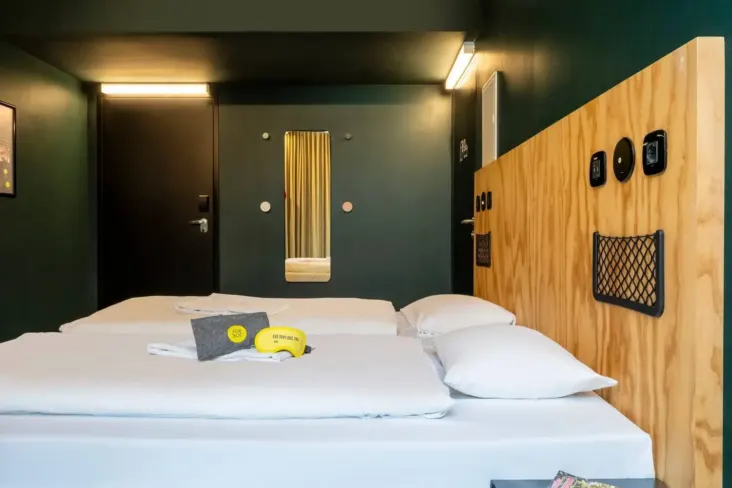 Chambre privée avec lit double et tête de lit en bois au JO&JOE Vienne