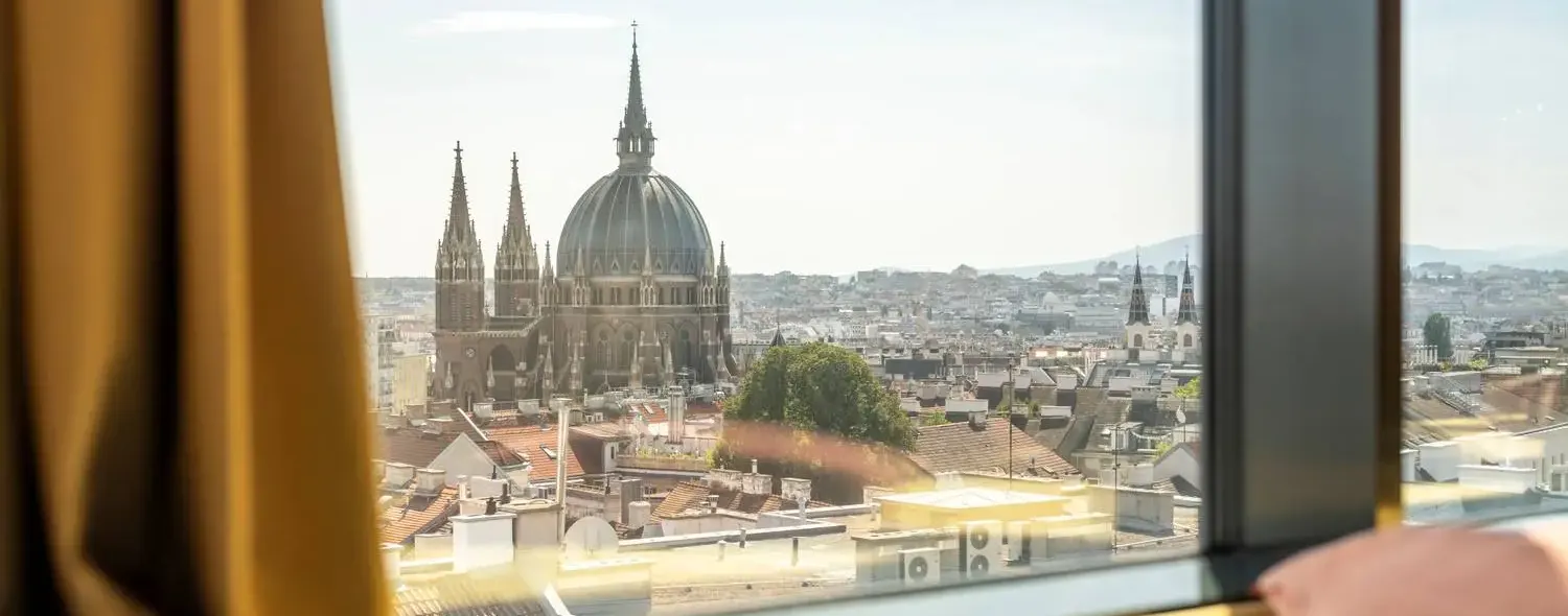 Vue depuis une chambre du JO&JOE Vienne sur les toits et un dôme d'église
